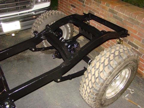 1948 Jeep Wrangler - The frame and suspension of a vehicle are shown, with large off-road tires mounted.