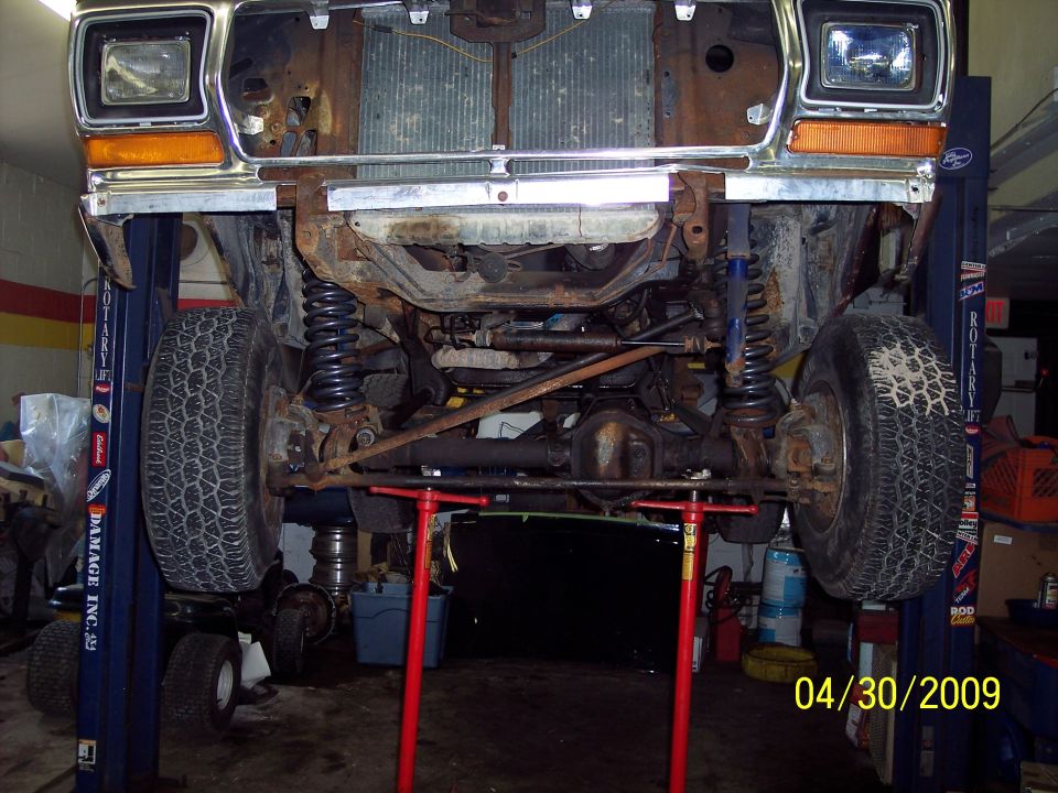 1979 Ford Bronco front undercarriage on lift, showing suspension and drivetrain