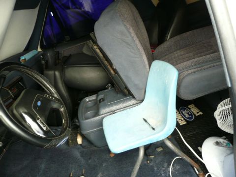 1991 Ford Bronco - The interior of a 1991 Ford Bronco is visible, with a steering wheel, center console, and an added blue seat.