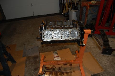 1994 Ford Bronco - Engine block with pistons exposed, resting on an engine stand in a workshop setting.