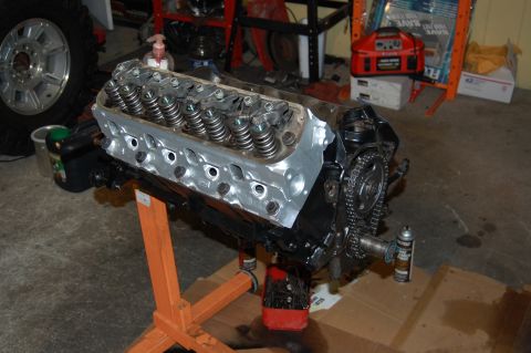 1994 Ford Bronco - Engine assembly displayed on an orange engine stand, with a tire and wheel visible in the background.