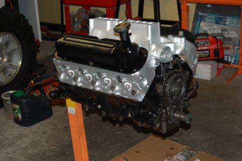1994 Ford Bronco - Engine assembly on a stand, with a tire and gas can nearby.