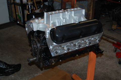 1994 Ford Bronco - Engine assembly with silver intake and black valve covers sits on an orange stand.
