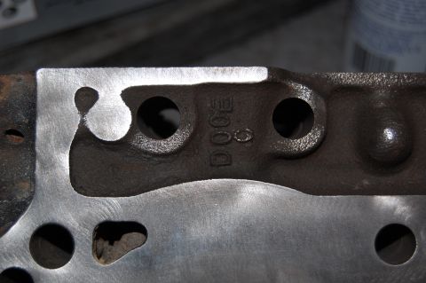 1994 Ford Bronco - Close-up of a machined engine component showing casting marks, including the text 'DOGE'.