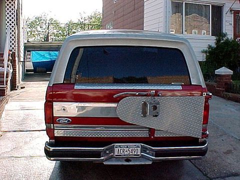 1983 Ford Bronco - Rear view of a 1983 Ford Bronco, a diamond plate spare tire carrier and a red and silver two-tone paint scheme.