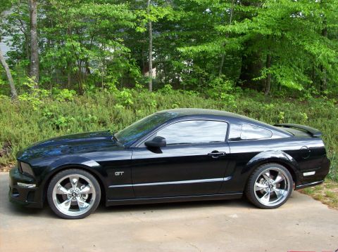 2007 Ford Mustang - Side profile of a black 2007 Ford Mustang GT with aftermarket wheels.