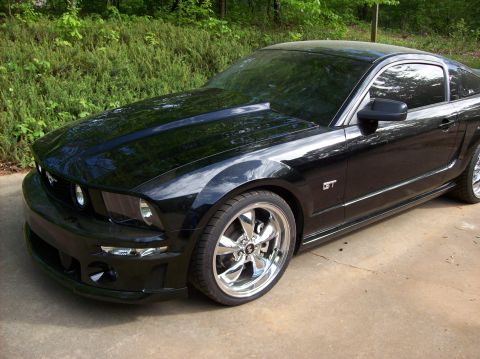 2007 Ford Mustang - A black Ford Mustang GT with a hood scoop and chrome wheels is parked outdoors.