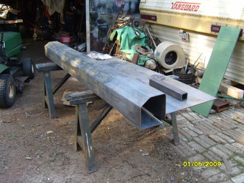 1989 Ford Bronco - A fabricated metal bumper part is shown resting on sawhorses, with a Vanguard trailer visible in the background.