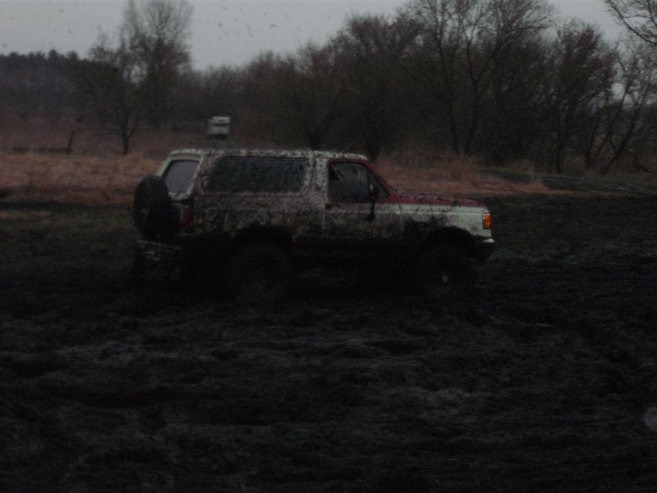 Mud-covered 1991 Ford Bronco stuck in mud, side view