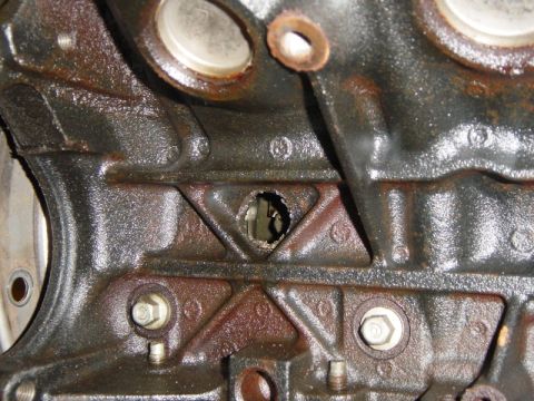 2007 Ford Mustang - Engine block with a hole drilled or punched through it, showing internal components.