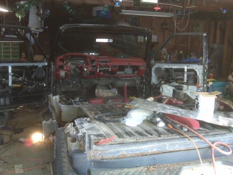 1995 Ford Bronco - Disassembled 1995 Ford Bronco interior and bed, showing removed dashboard and doors.