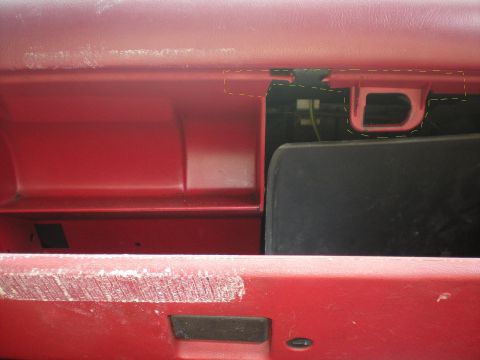 1990 Ford Bronco - The interior of a red glove box shows wear and tear around the latch mechanism.