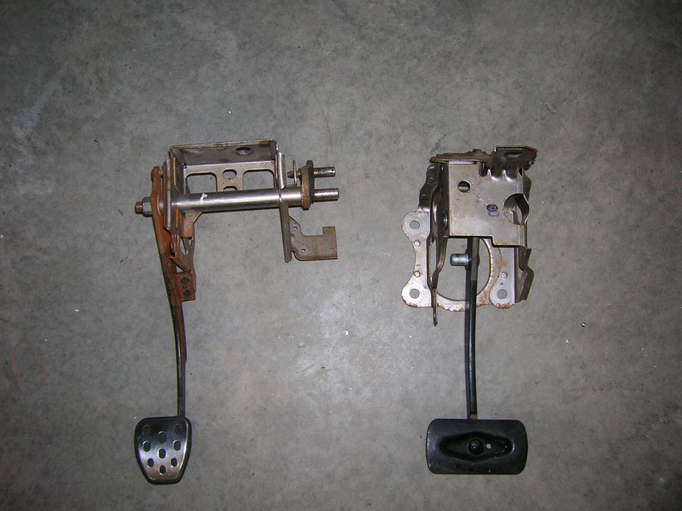 Two removed pedal assemblies with brackets lying on a concrete floor
