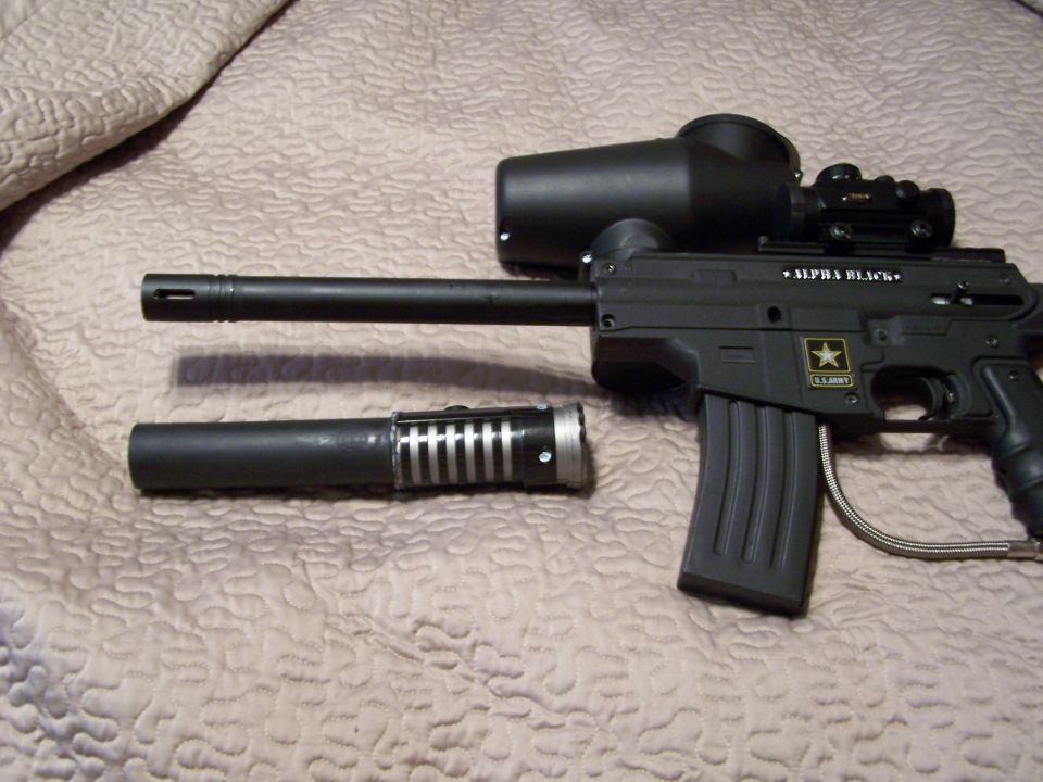 Black paintball marker with "ALPHA BLACK" text and U.S. Army logo, next to a removable barrel
