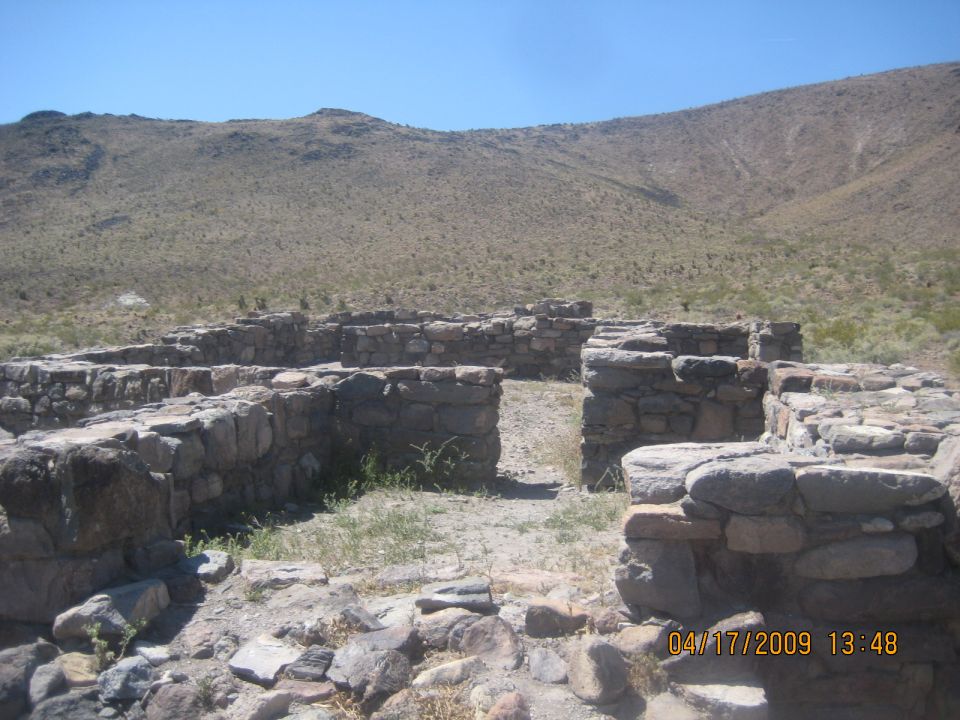 Ruins of a stone structure in a desert landscape.