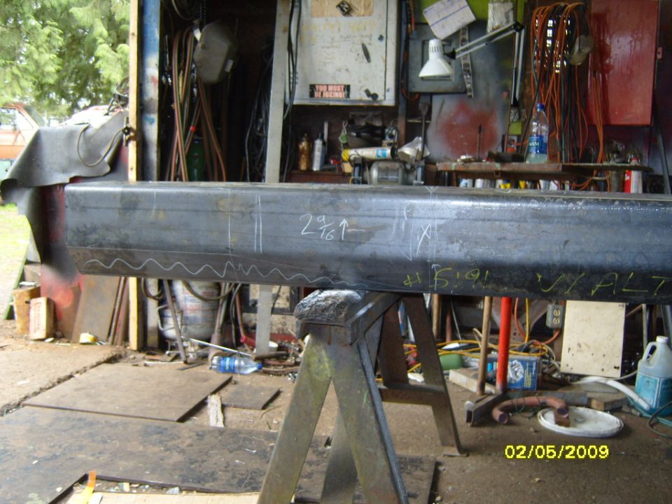 Metal beam with chalk markings in a workshop.