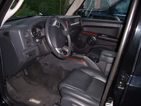 1978 Ford Bronco - The interior of a black Jeep SUV is shown, focusing on the driver's side dashboard, steering wheel, and front seats. A Jeep logo is visible…