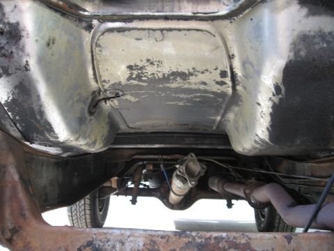 1966 Ford F-100 - This photo shows the underside of a truck, focusing on the rear axle and suspension system, likely during a paint preparation process.