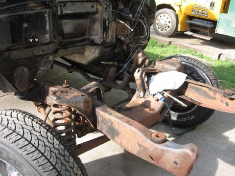 1966 Ford F-100 - Hands are working on the engine bay of a truck, with a tire in the foreground.
