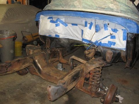 1966 Ford F-100 - The chassis and front clip of a 1966 Ford F-100 are shown during paint preparation, with the front end covered in protective materials.
