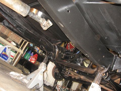 1966 Ford F-100 - The underside of a vehicle is shown on jack stands, with a Confederate flag visible in the background.