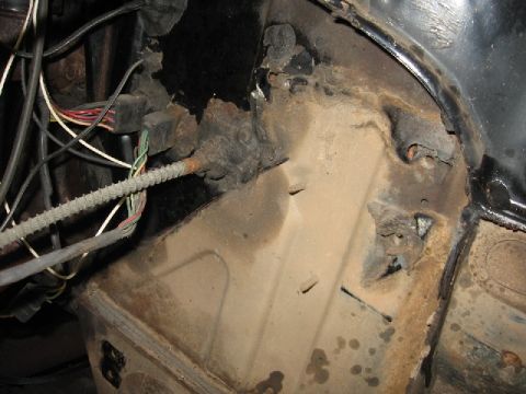 1966 Ford F-100 - Rusted metal and exposed wiring are visible in the engine bay of an older vehicle.