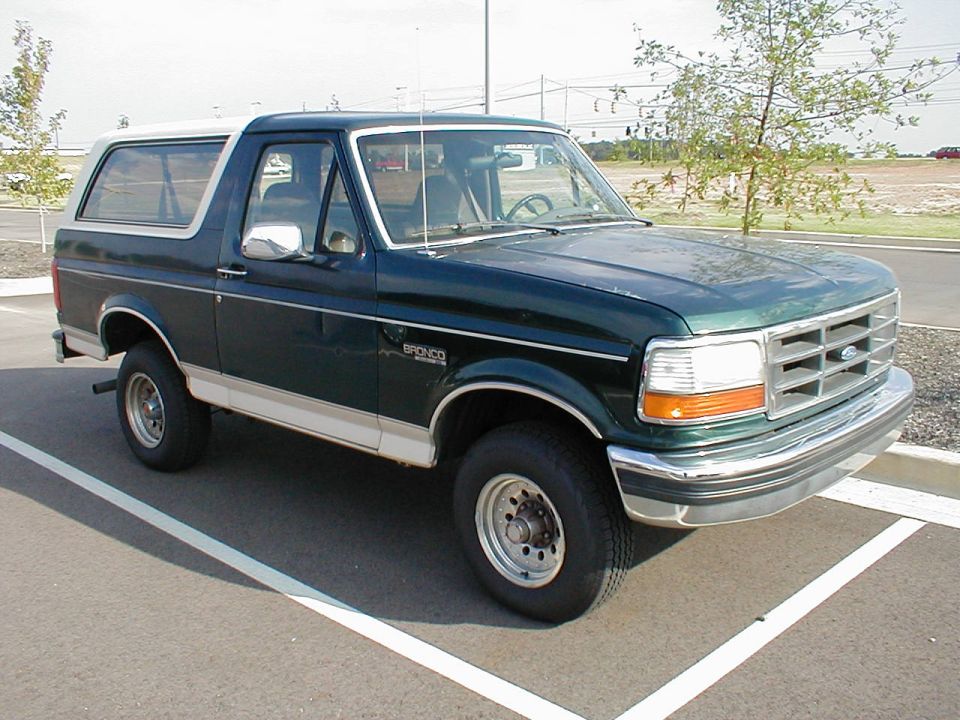Green and white Ford Bronco SUV parked, front three-quarter view