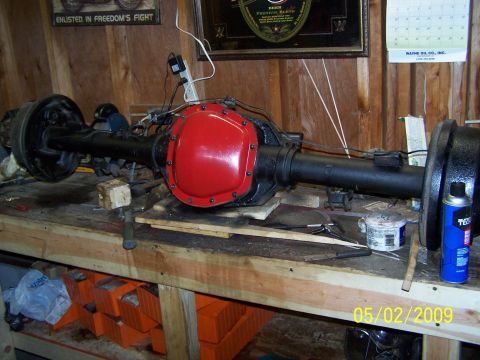 1989 Ford F-150 - A rear axle assembly is shown on a workbench, with tools and supplies nearby.