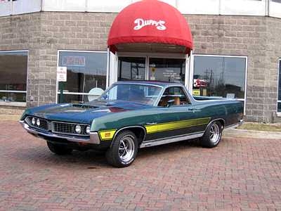 1971 Ford Ranchero - This green and yellow pickup truck is parked in front of a building with a red awning. The 'SUPERMOTORS' watermark is visible.