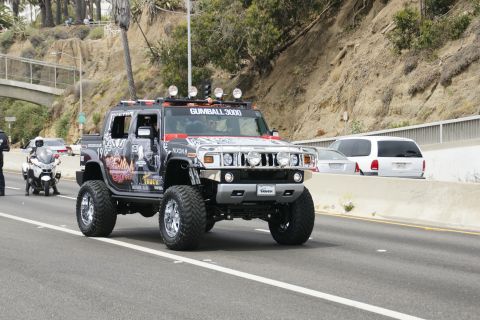 1993 Ford Taurus - A modified Hummer H2 with extensive decals and roof lights is seen on the road.