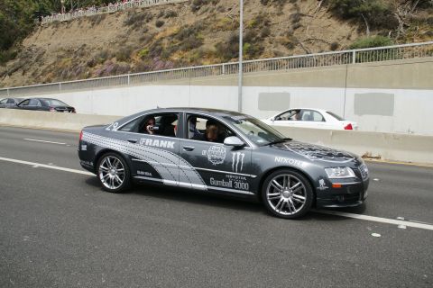 1993 Ford Taurus - This dark sedan features prominent Gumball 3000 branding, including Monster Energy and Nixon logos, on its exterior.
