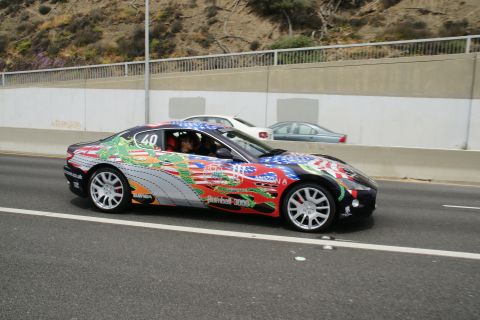 1993 Ford Taurus - A heavily decorated sports car with a dragon motif and American flag elements is seen on the road, with other vehicles in the background.