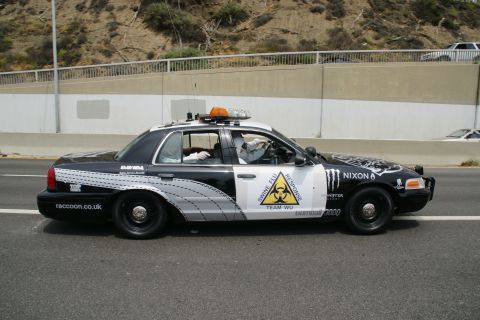 1993 Ford Taurus - A modified police car with "Swine Flu Response Team Wu" and "Nixon" graphics drives on a highway.