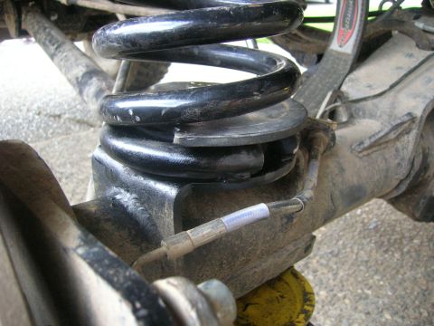 1996 Ford Bronco - Detail of a vehicle's rear suspension system, focusing on the coil spring and associated components.