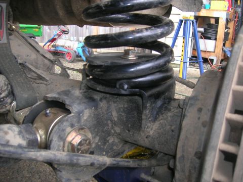 1996 Ford Bronco - A close-up view of a vehicle's rear suspension component, focusing on the coil spring.