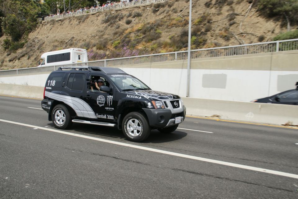 Black SUV with Monster Energy and Nixon decals, number 118, driving on a highway