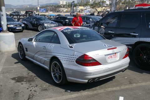 1993 Ford Taurus - A silver Mercedes-Benz SL65 AMG is parked in a lot with other vehicles, displaying Gumball 3000 branding.
