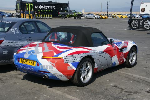 1993 Ford Taurus - A custom-liveried convertible is parked next to another car, with a Monster Energy truck in the background.