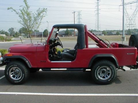1983 Ford Bronco - This red Jeep CJ-7 is seen from the side, a black soft top and roll bar.