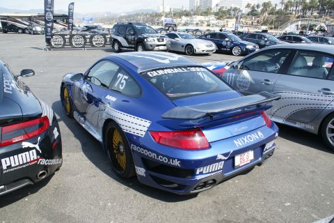 1993 Ford Taurus - A blue Porsche 911 Turbo is parked next to a black Porsche, both with racing decals.