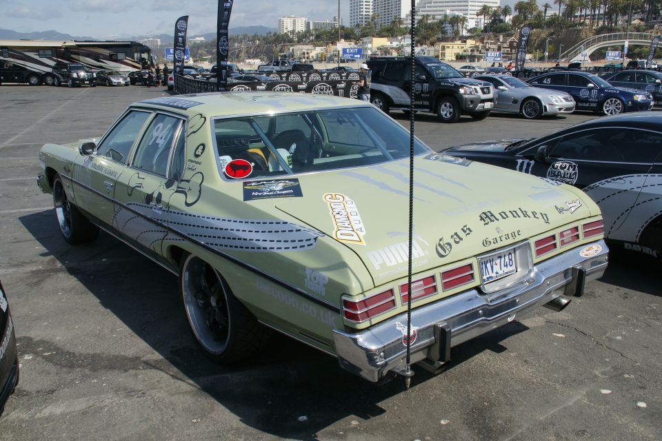 Light green sedan with 'Gas Monkey Garage' decal, custom graphics, and license plate KXY-748