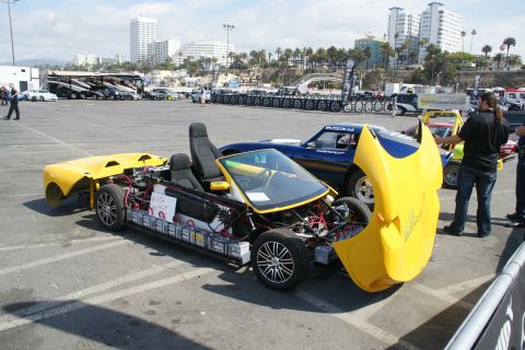1993 Ford Taurus - A custom-built electric vehicle chassis is displayed with its body panels removed, revealing its internal components and battery pack.