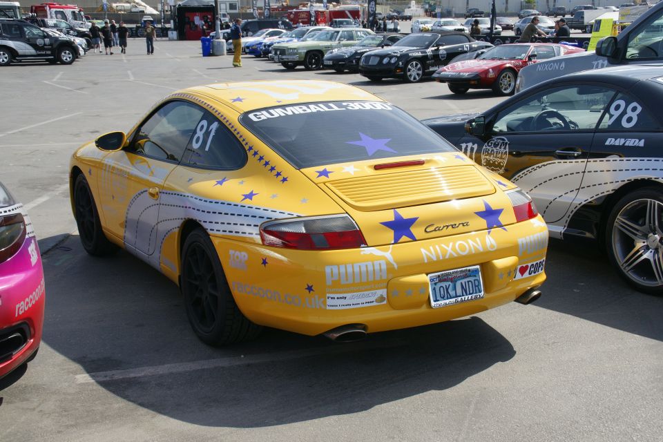 Yellow Porsche Carrera with Gumball 3000 livery, rear view