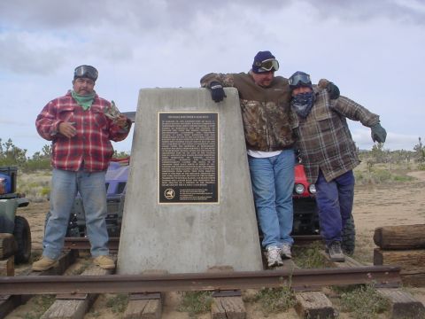1994 Ford Bronco - Men pose at a Nevada Southern Railway historical marker, with ATVs in the background.