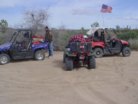 1994 Ford Bronco - Three ATVs are parked in a desert area with sparse vegetation and a dusty ground.