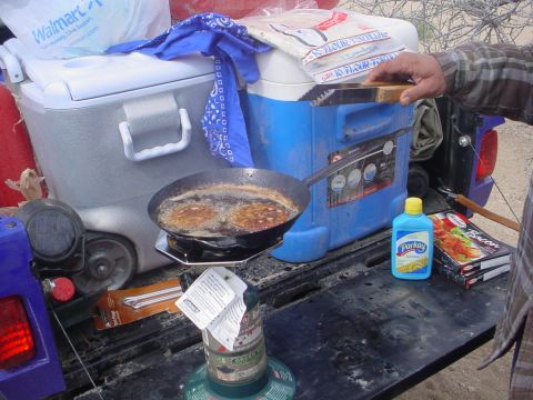 1994 Ford Bronco - Cooking breakfast on a tailgate with coolers and camping gear.