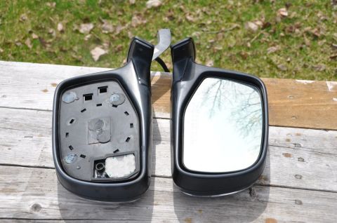 1996 Ford Bronco - Photo of two exterior side mirrors on a wooden surface, not a technical document.