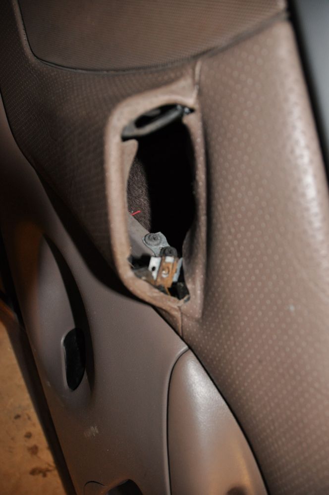 Close-up of a door panel pocket with exposed latch mechanism