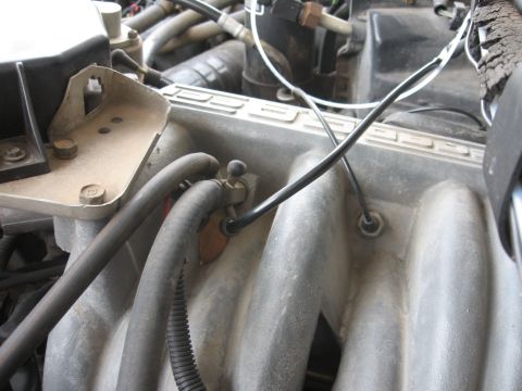 1990 Ford F-150 - A close-up view of the intake manifold and various hoses on a Ford F-150 engine. The manifold is gray and textured, with several black rubb…