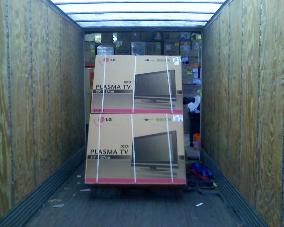 Two stacked LG Plasma TV boxes inside a cargo trailer.